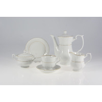 Biały porcelanowy garnitur do kawy Chodzież Iwona B014 ze złotym zdobieniem. Zestaw zawiera dzbanek, cukiernicę, mlecznik oraz filiżankę ze spodkiem na jasnym
