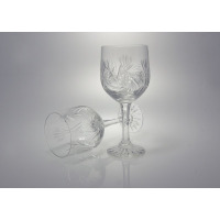 Dwa kryształowe kieliszki goblet 240g Monica marki Zawiercie z ozdobnym szlifem w kształcie gwiazd. Jeden stoi pionowo, drugi leży obok na jasnym tle.
