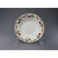 Salaterka okrągła 23 cm B013 Iwona marki Chodzież z klasycznym motywem róż na białej porcelanie, wykończona złotym rantem, prezentowana na przezroczystym