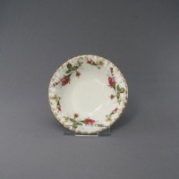 Salaterka okrągła 13 cm B013 Iwona marki Chodzież z białej porcelany, ozdobiona klasycznym motywem róż i złotym wykończeniem brzegów, widok z góry na podstawce.