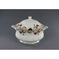 Porcelanowa waza 2,50 l Iwona Złota róża marki Chodzież z pokrywką. Białe naczynie o pofalowanych brzegach zdobią motywy róż i złocenia. Widok z profilu.