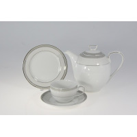 Garnitur do kawy Chodzież E685 Yvonne: biała porcelana ze srebrnym zdobieniem, obejmująca dzbanek, filiżankę ze spodkiem oraz talerzyk deserowy na jasnym tle.