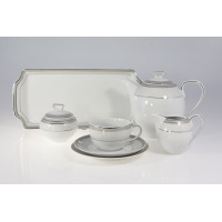Elegancki garnitur do kawy E685 YVONNE marki Chodzież. Biała porcelana z subtelnym srebrnym zdobieniem, obejmująca dzbanek, cukiernicę, mlecznik oraz filiżankę.