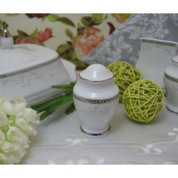 Biała porcelanowa pieprzniczka Ćmielów B601 Astra z eleganckim srebrnym zdobieniem w geometryczne wzory i motywem roślinnym, wyeksponowana na jasnym obrusie.
