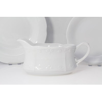 Sosjerka z białej porcelany Chodzież Kamelia z tłoczonym ornamentem, widoczna z profilu na tle dwóch talerzy z tego samego serwisu obiadowego dla 12 osób.