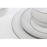 Zbliżenie na porcelanowy zestaw kawowy E373 Yvonne marki Chodzież. Białe naczynia zdobi subtelny, szary ornament roślinny oraz eleganckie wykończenie srebrną