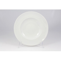 Biały talerz głęboki do spaghetti KASZUB marki Lubiana o średnicy 29 cm. Klasyczna porcelana z szerokim rantem, wyeksponowana na przezroczystym stojaku.