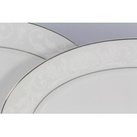 Zbliżenie na białą porcelanę Chodzież z serwisu obiadowego E373 YVONNE. Widoczny subtelny, jasnoszary roślinny ornament na obrzeżach talerzy z eleganckim