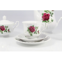 Porcelanowy zestaw kawowy Chodzież Iwona B826 z motywem bordowej róży. Zbliżenie na filiżankę ze spodkiem, cukiernicę i dzbanek o klasycznym, żłobkowanym