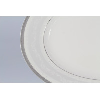 Zbliżenie na krawędź owalnego półmiska Karolina Lorel D-7394/1. Biała porcelana z subtelnym, szarym wzorem roślinnym i geometrycznym zdobieniem na obrzeżu.