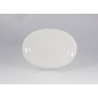 Biały, owalny półmisek Lubiana Jupiter o średnicy 28 cm. Klasyczna, gładka porcelana o minimalistycznym designie, ustawiona na przezroczystym stojaku