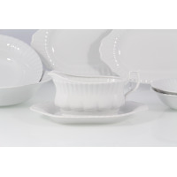 Sosjerka z białej porcelany Chodzież Iwona o klasycznym, żłobkowanym wzorze, ustawiona na dopasowanej podstawce w ramach serwisu obiadowego dla 12 osób.