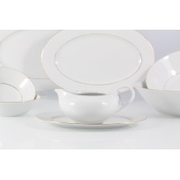 Sosjerka z zestawu obiadowego Chodzież Yvonne na 12 osób. Biała porcelana ze złotym zdobieniem na spodku i krawędziach, wyeksponowana na tle pozostałych naczyń.