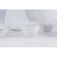 Biała filiżanka z platynową linią z zestawu kawowego dla 12 osób Chodzież Akcent. W tle widoczny spodek i dzbanek z tej samej eleganckiej kolekcji porcelany.