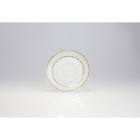 Biały porcelanowy spodek 14 cm z serii B601 ASTRA marki Ćmielów. Naczynie zdobią dwa koncentryczne, srebrne pasy z geometrycznym wzorem kwadratów na obrzeżach.