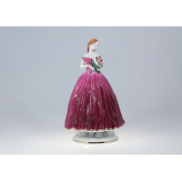 Porcelanowa figurka Markiza z manufaktury Ćmielów. Elegancka dama w długiej, bordowej sukni z delikatnymi złoceniami, trzymająca bukiet kwiatów. Widok z przodu.