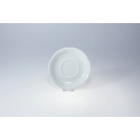 Biały porcelanowy spodek 16 cm z kolekcji Kamelia marki Chodzież. Naczynie o klasycznym, okrągłym kształcie z delikatnie falowanym brzegiem, widok z góry.