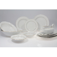 Biały serwis obiadowy Chodzież Maria Teresa B014 na 12 osób. Zestaw porcelany z delikatnym złotym zdobieniem, obejmujący talerze, miski i sosjerkę na tle.