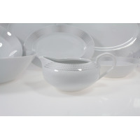 Sosjerka z serwisu obiadowego Chodzież G465 Yvonne. Biała porcelana z subtelnym, szarym wzorem kropek na krawędziach, ustawiona na pierwszym planie zestawu.