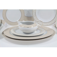 Elegancki serwis obiadowy Chodzież G620 Yvonne dla 12 osób. Biała porcelana z subtelnym, beżowym zdobieniem i złotym wykończeniem, widoczna sosjerka na talerzu.