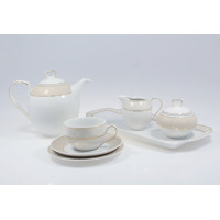 Elegancki garnitur do kawy Chodzież G620 Yvonne dla 12 osób. Biała porcelana ze złotym, ażurowym wzorem na dzbanku, cukiernicy, mleczniku i filiżance na spodku.