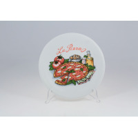 Talerz do pizzy 27 cm 0053 BARILLA marki Lubiana na przezroczystym stojaku. Białe naczynie z kolorowym nadrukiem pizzy, pomidorów, oliwy i napisem La Pizza.