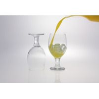 Szklanki na nodze MISKET marki LAV o pojemności 400 ml. Jedna szklanka wypełniona lodem i nalewanym sokiem, druga odwrócona do góry dnem na jasnym tle.