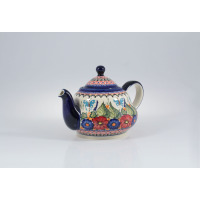 Ceramiczny czajnik Bolesławiec o pojemności 1,50 l, model 149AR. Naczynie zdobi ręcznie malowany wzór w niebieskie motyle oraz czerwone i niebieskie kwiaty.