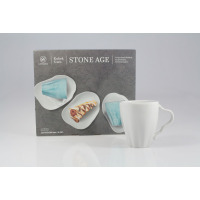 Biały kubek z zestawu 6 szt. Stone Age marki Lubiana o pojemności 350 ml. Obok opakowanie z nadrukiem niebieskich naczyń i deserem. Nowoczesny design