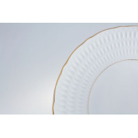 Zbliżenie na białą porcelanę Ćmielów z kolekcji Sofia. Półmisek o średnicy 24 cm z delikatnym, tłoczonym wzorem na rancie oraz eleganckim, złotym wykończeniem