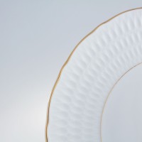 Zbliżenie na biały spodek 15,7 cm Sofia marki Ćmielów. Porcelanowy talerzyk z delikatną, tłoczoną teksturą na obrzeżu oraz eleganckim, złotym wykończeniem