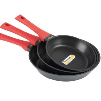 Trzy patelnie Zwieger Obsidian o różnych rozmiarach ułożone jedna w drugiej. Naczynia mają czarne wnętrze z powłoką Greblon C3 i czerwone, ergonomiczne uchwyty.