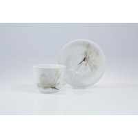 Biały porcelanowy kubek 300 ml ze spodkiem Lubiana 6474 Magnolia (Wiedeń) z delikatnym szarym motywem kwiatowym, ustawiony na jasnym tle w ujęciu z boku.