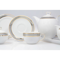 Elegancki zestaw kawowy Chodzież G627 Yvonne. Biała porcelana ze srebrno-złotym zdobieniem: filiżanka ze spodkiem, dzbanek i cukiernica na jasnym tle.