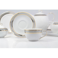Garnitur do kawy Chodzież G627 Yvonne dla 12 osób. Biała porcelana ze srebrno-szarym ornamentem i złotymi liniami. Filiżanka na pierwszym planie, w tle dzbanek