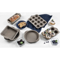 Zestaw silikonowych form do pieczenia Gerlach w kolorze taupe, obejmujący keksówkę, formy na muffiny, tortownicę i kwadratową blachę, w otoczeniu gotowych