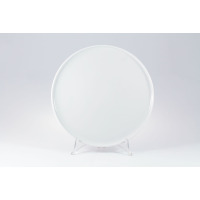 Biały talerz płytki Ankara o średnicy 26 cm marki Lubiana. Klasyczna, gładka porcelana o minimalistycznym designie, wyeksponowana na przezroczystym stojaku.