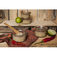 Słoiki Weck Mold 290 ml wypełnione pastą, ustawione na drewnianym blacie obok limonek i papryczek chili. Szklane naczynia z charakterystycznymi gumowymi