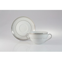 Biała bulionówka 0,35 l ze spodkiem Ćmielów E685 Yvonne. Porcelanowe naczynie z dwoma uszkami i delikatnym srebrnym zdobieniem w stylu klasycznym na jasnym tle.