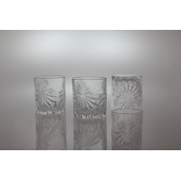 Trzy szklanki kryształowe Bohemia Prestige Fiore 320 ml z ozdobnym szlifem w kształcie gwiazd. Dwie stoją pionowo, jedna odwrócona dnem do góry na jasnym tle.