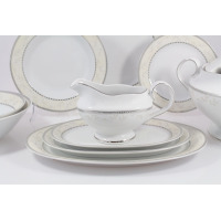 Elegancka sosjerka z serwisu obiadowego B601 Astra marki Ćmielów, ustawiona na owalnym półmisku. Biała porcelana z delikatnym roślinnym wzorem i srebrnym
