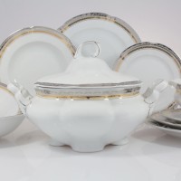 Serwis obiadowy Ćmielów E551 Bolero Princess dla 6 osób. Biała porcelana ze złotym i srebrnym zdobieniem, waza z pokrywką na pierwszym planie, talerze i