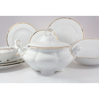 Elegancki serwis obiadowy Ćmielów E337 Bolero dla 6 osób. Biała porcelana z delikatnym złotym paskiem, w tym waza z pokrywką, talerze i salaterka na białym tle.