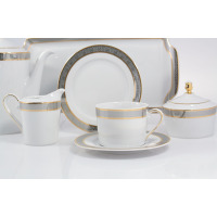 Elegancki serwis obiadowy Ćmielów G626 JENNY z białej porcelany, zdobiony szarym greckim wzorem ze złotymi liniami. Widoczny dzbanek, cukiernica, filiżanka i