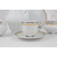 Zestaw do kawy Ćmielów E551 BOLERO Princess dla 6 osób. Biała porcelana ze złotym i srebrnym zdobieniem, widoczna filiżanka na spodku, dzbanek oraz cukiernica.