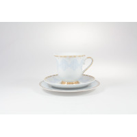 Porcelanowy zestaw kawowy Ćmielów G684 Astra Królewski błękit. Filiżanka ze spodkiem na białym tle, zdobiona błękitnym ornamentem i złotymi wykończeniami.