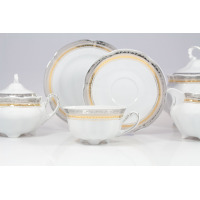 Zestaw do herbaty Ćmielów E551 Bolero Princess. Biała porcelana ze złotym i srebrnym zdobieniem, filiżanka na nóżkach, spodek, cukiernica i dzbanek na jasnym