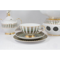 Zestaw do herbaty Ćmielów G413 ASTRA India: filiżanka ze spodkiem na pierwszym planie, obok cukiernica i podgrzewacz. Biała porcelana z eleganckim