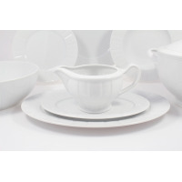 Biały sosjerka z kolekcji OKTAWA 0001 marki Ćmielów ustawiona na dwóch talerzach. Klasyczna porcelana o subtelnym, żłobkowanym wzorze w eleganckim zestawie