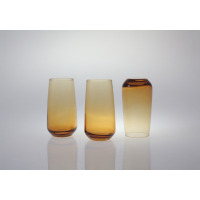 Trzy szklanki wysokie 430 ml Sunset Miodowy marki Glasmark. Dwie stoją pionowo, trzecia jest odwrócona dnem do góry, ukazując gradientowy, miodowy odcień szkła.